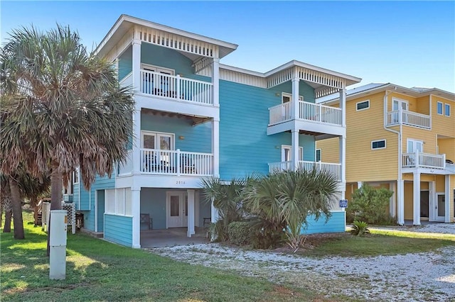 back of house featuring a balcony and a lawn