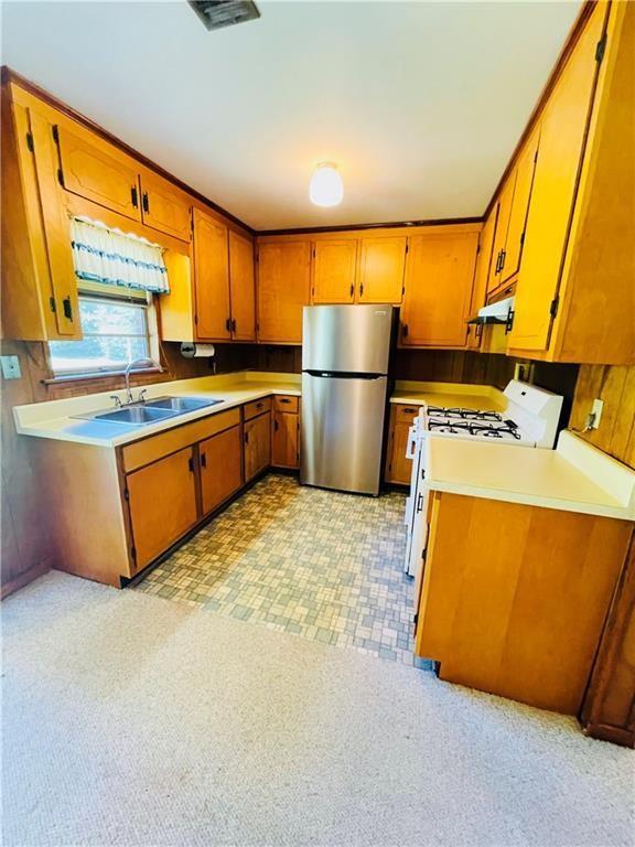 kitchen featuring stainless steel refrigerator, sink, and gas range gas stove