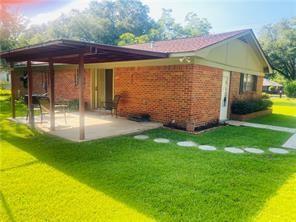 back of house with a lawn and a patio area