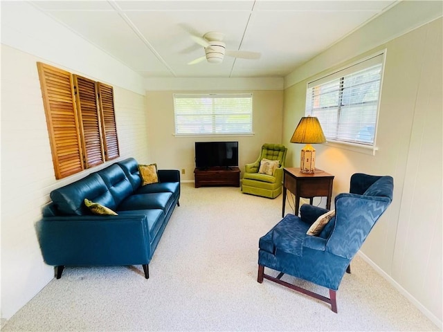 living room with a wealth of natural light, ceiling fan, and carpet flooring