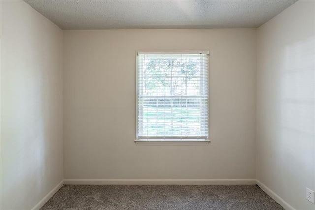 carpeted empty room with a textured ceiling