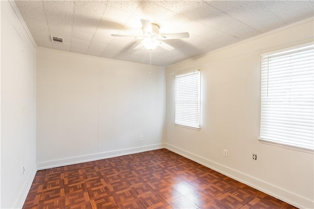 unfurnished room featuring ceiling fan, dark parquet flooring, and ornamental molding