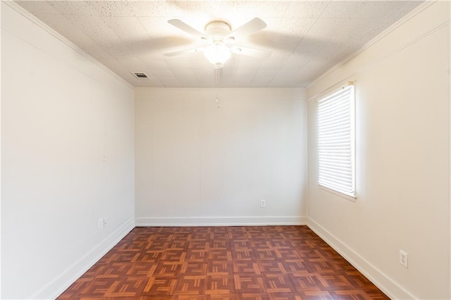 spare room with dark parquet flooring, ceiling fan, and ornamental molding