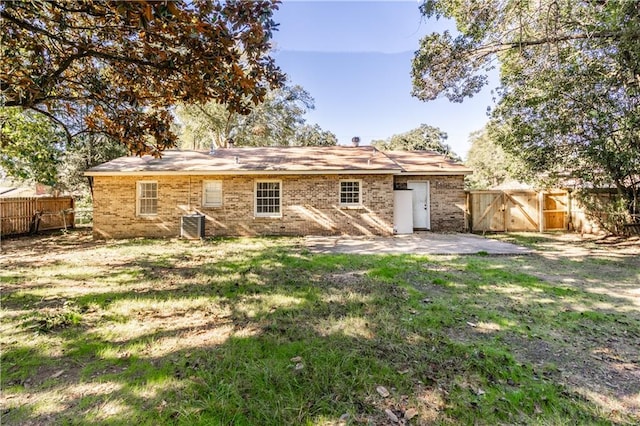 back of property with a yard and central AC unit