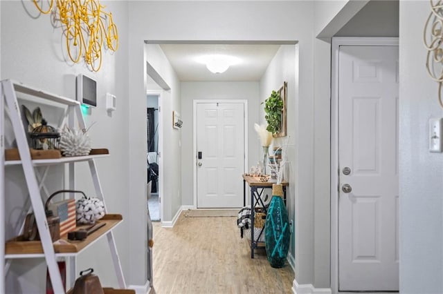 entryway with baseboards and wood finished floors