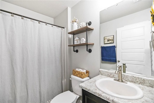 bathroom featuring toilet, a textured ceiling, a shower with shower curtain, and vanity