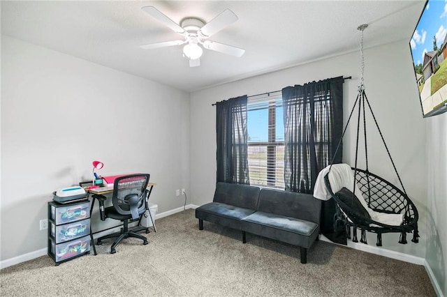 carpeted office featuring a ceiling fan and baseboards