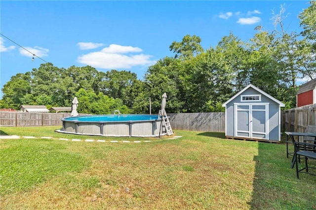 view of yard with a storage shed, a fenced backyard, a fenced in pool, and an outbuilding