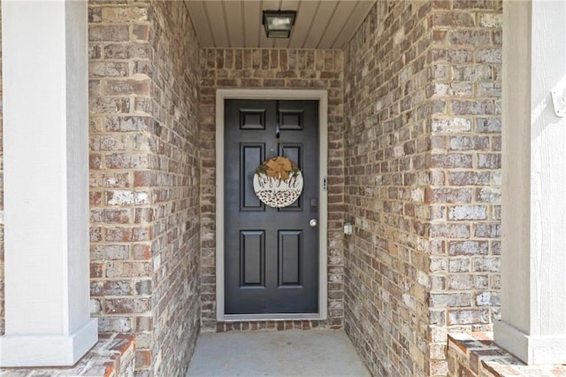 entrance to property featuring brick siding