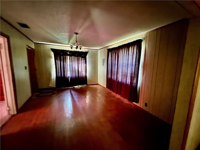 entryway featuring an inviting chandelier, crown molding, visible vents, and wood finished floors