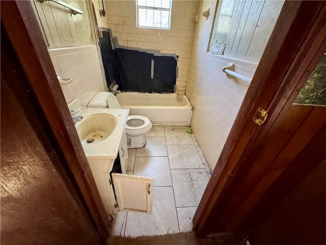 bathroom featuring vanity, tile walls, and toilet
