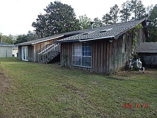 rear view of house featuring a lawn