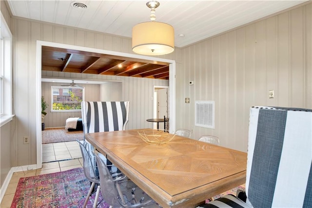 dining area featuring wood ceiling, ceiling fan, wood walls, and light tile patterned flooring