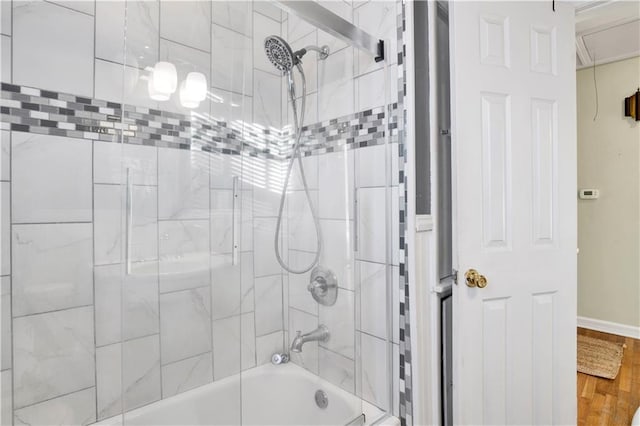 bathroom with wood-type flooring and tiled shower / bath