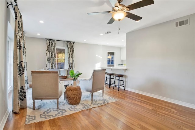 living area featuring light hardwood / wood-style floors and ceiling fan