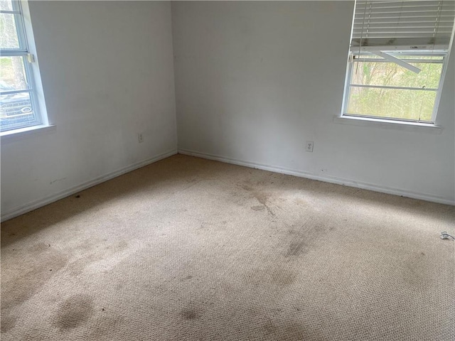 carpeted empty room with baseboards