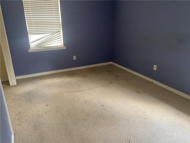 spare room featuring baseboards and carpet