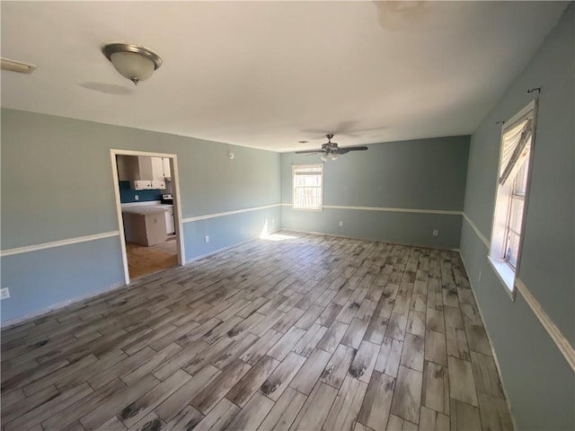 unfurnished room featuring visible vents, a ceiling fan, and wood finished floors