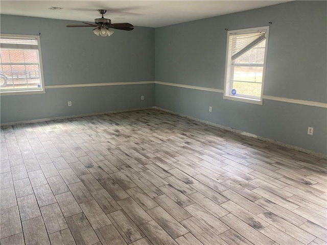 spare room featuring wood finished floors, visible vents, and ceiling fan