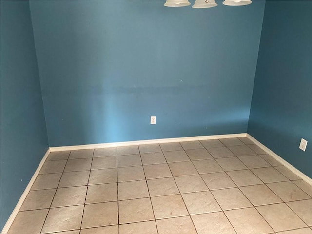 unfurnished room featuring light tile patterned floors and baseboards