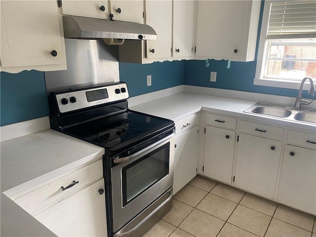 kitchen featuring under cabinet range hood, a sink, white cabinetry, light countertops, and stainless steel electric range oven