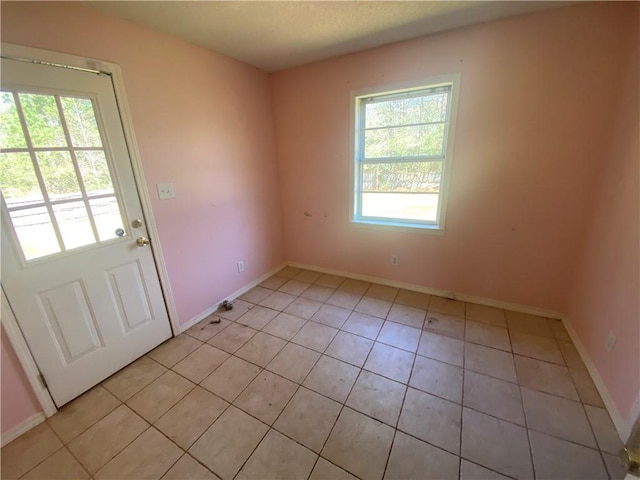 interior space with light tile patterned floors and baseboards