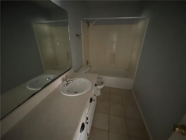 bathroom with tile patterned flooring, baseboards, shower / washtub combination, toilet, and vanity