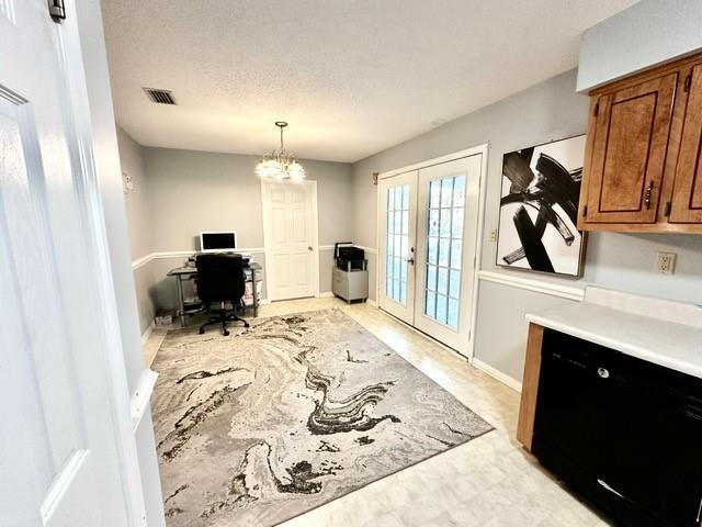 home office featuring french doors, visible vents, a chandelier, and a textured ceiling