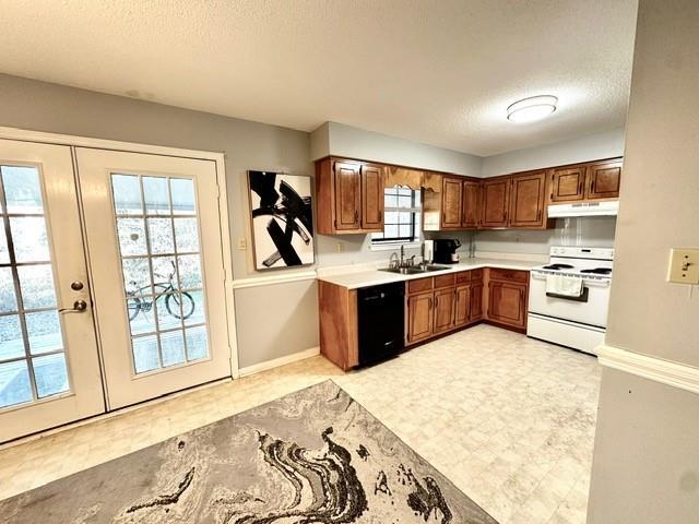 kitchen featuring electric range, a sink, black dishwasher, under cabinet range hood, and a textured ceiling