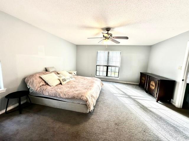 carpeted bedroom featuring a textured ceiling and ceiling fan