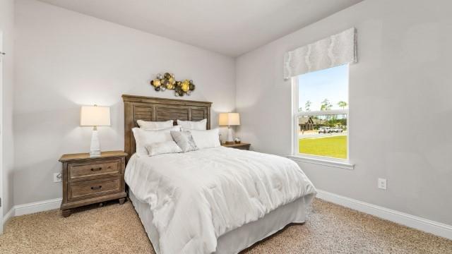 bedroom featuring carpet and baseboards