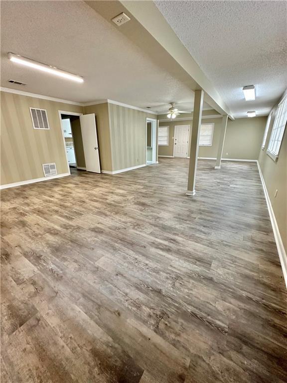 5405 Moffett Rd, Mobile, AL 36618 - basement featuring a textured ceiling, visible vents, and wood finished floors