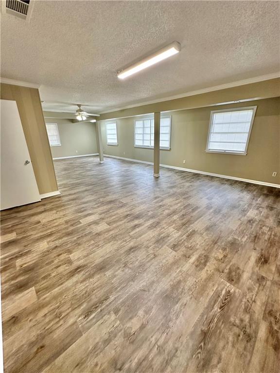 5405 Moffett Rd, Mobile, AL 36618 - basement featuring ornamental molding, a textured ceiling, visible vents, and wood finished floors