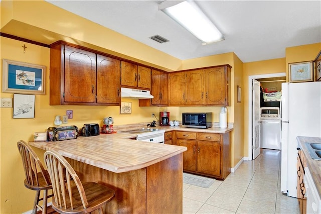 2805 Brookside Dr, Mobile, AL 36693 - kitchen with a kitchen breakfast bar, kitchen peninsula, light tile patterned flooring, and white appliances
