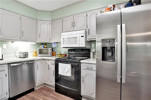 kitchen featuring white cabinets, light wood-style flooring, stainless steel appliances, and light countertops