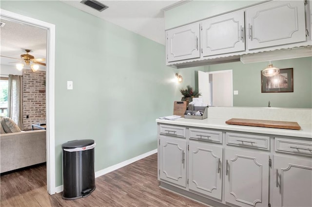 kitchen featuring ceiling fan, wood finished floors, visible vents, and light countertops