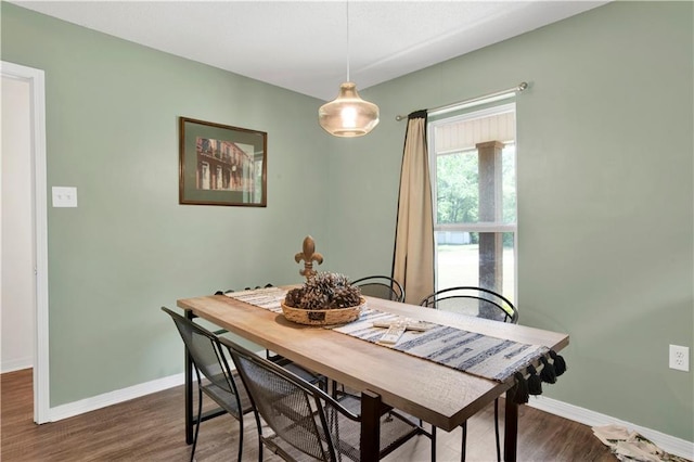 dining room with dark wood-type flooring and baseboards