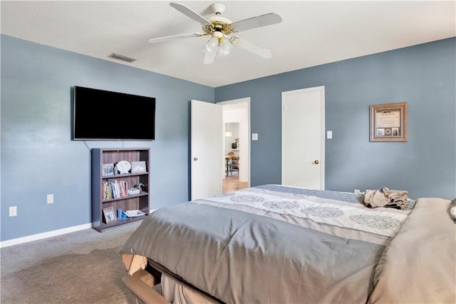 carpeted bedroom with visible vents, baseboards, and ceiling fan