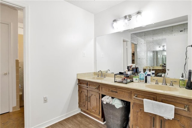 full bath featuring wood finished floors, a sink, and double vanity
