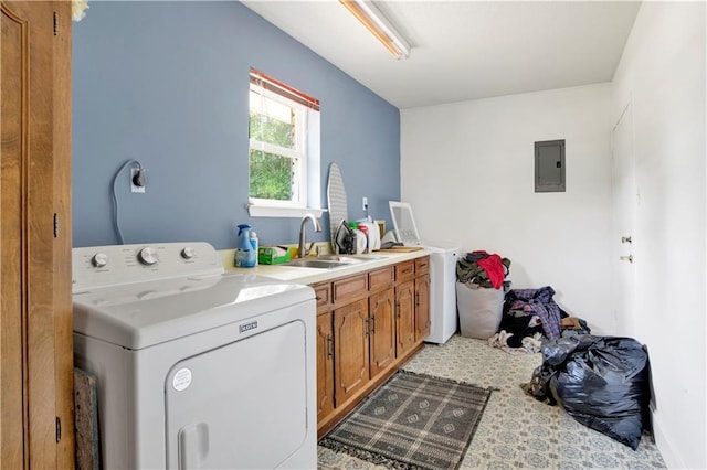 laundry area featuring electric panel, a sink, washer and dryer, and cabinet space