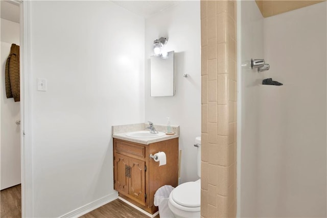 bathroom with walk in shower, toilet, vanity, and wood finished floors