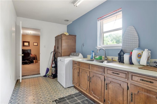 laundry room with light floors, washer / dryer, cabinet space, and a sink