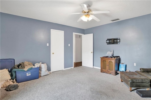 sitting room featuring ceiling fan, carpet floors, visible vents, and baseboards
