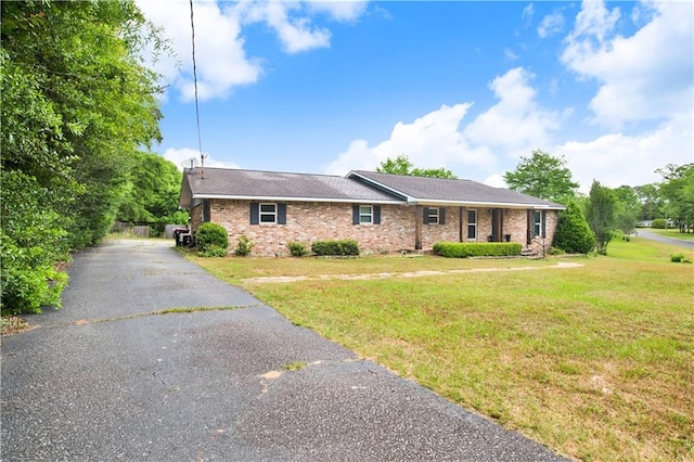 single story home featuring brick siding and a front yard