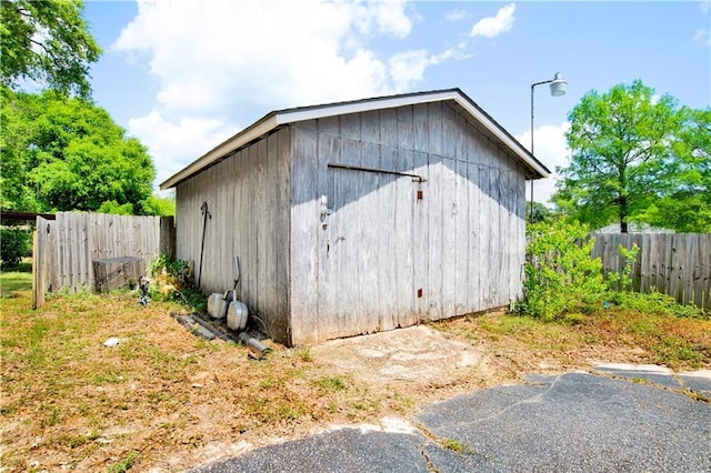 view of outbuilding featuring an outdoor structure and fence