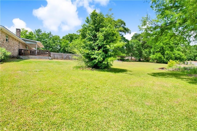 view of yard featuring fence and a deck