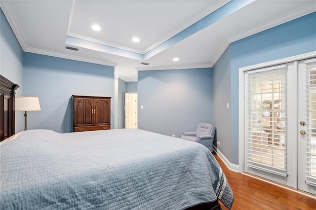 bedroom with ornamental molding, a tray ceiling, access to outside, and light wood-type flooring