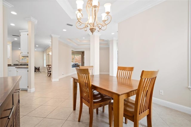 tiled dining area with ornate columns, sink, ornamental molding, a notable chandelier, and a tray ceiling