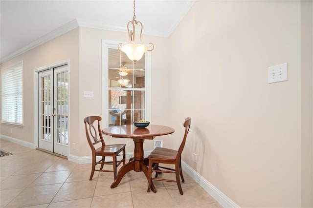 tiled dining area with crown molding and french doors