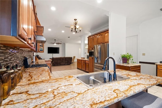 kitchen featuring sink, light tile patterned floors, appliances with stainless steel finishes, kitchen peninsula, and decorative backsplash